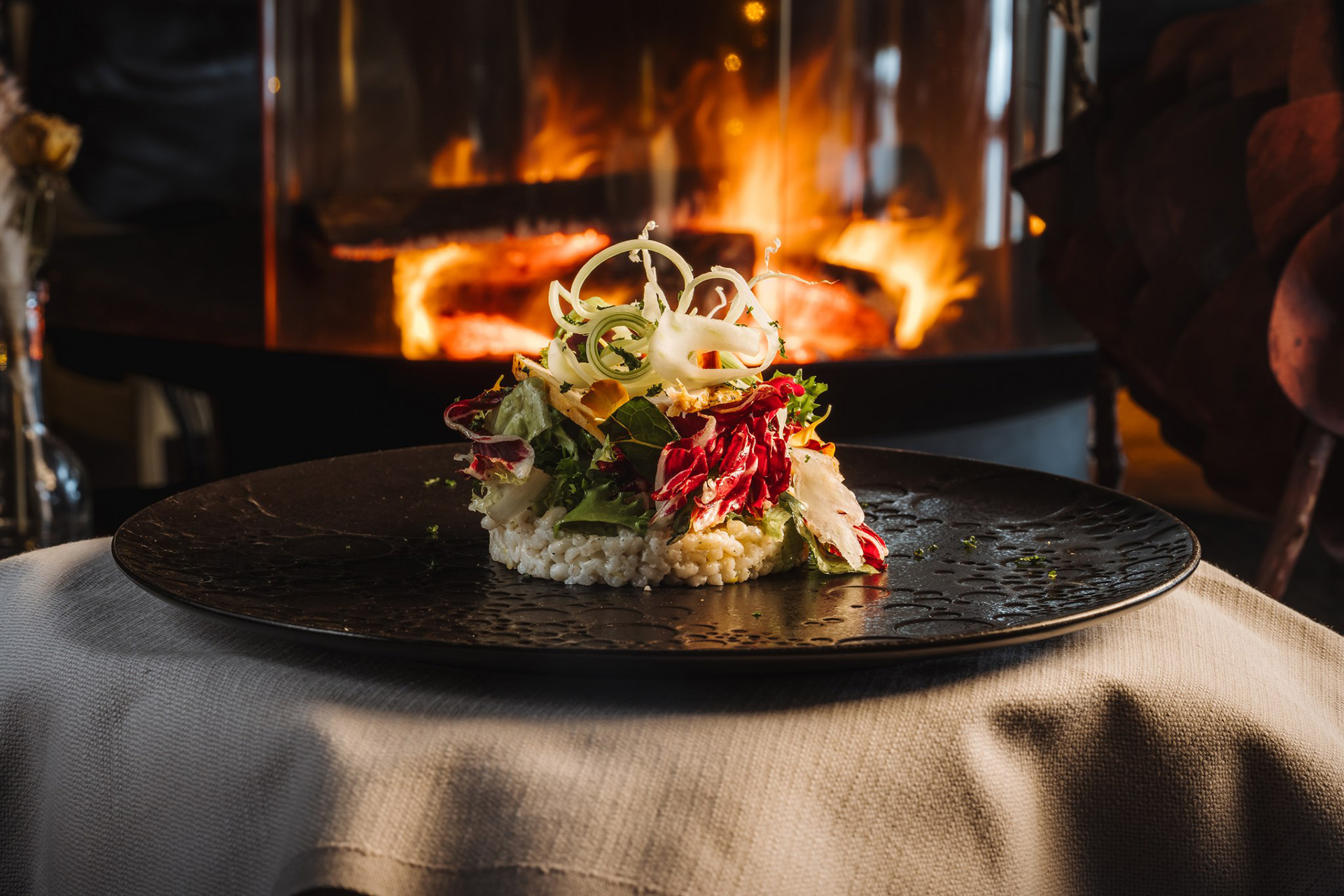 Dish from Rakas winter menu in front of the fireplace.